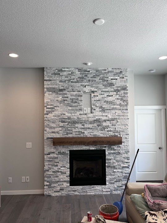 Real floor-to-ceiling stone fireplace project by Yovani's Repair LLC